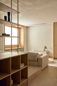 Furnished living room with wooden furniture, a window, and natural light creating a warm atmosphere