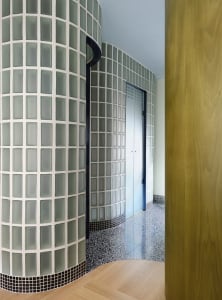Modern bathroom with a tiled floor and walls, featuring a patterned tile design and natural light from a window