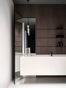 A modern bathroom with a white sink, marble countertop, and a wooden cabinet, well-lit with a mirror above the sink