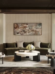 A modern living room with a green sofa, coffee table, chair, and vase, well-lit and inviting