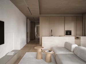 A modern living room with a white couch, dining table, kitchen area, wooden coffee table, and chair, decorated with books and a vase, in a predominantly white space with a bright and airy feel