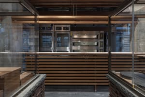 Bright and inviting kitchen with a large window, wood counter, and stainless steel oven, refrigerator, and appliances