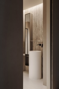 A well-lit bathroom with a white toilet, sink, and mirror, creating a clean and modern atmosphere