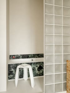 A modern bathroom with a white toilet and sink, marble countertop, and dim lighting creating a cozy atmosphere