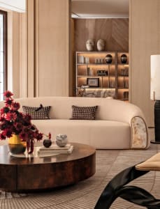 Comfortable living space with a large white couch, coffee table, fireplace, and decorative items, well-lit and inviting