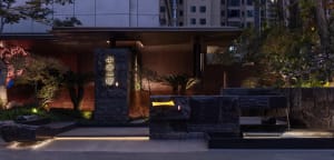 A modern building with a stone facade, brick wall, and dim lighting creating a moody atmosphere