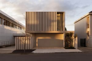 A modern house with a large window and garage, exterior made of concrete, with natural light and a minimalist design
