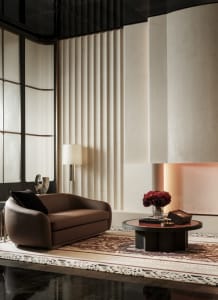 Cozy living room with a brown couch and chair, a fireplace, and a large window providing natural light