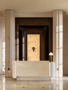 A modern bathroom with a white marble countertop, a gold lamp, and a sink and mirror, creating a luxurious and elegant space