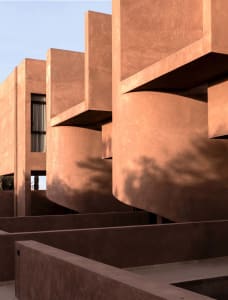 A serene outdoor space with a red brick building featuring a unique curved design and staircase, set in a calm courtyard or public area