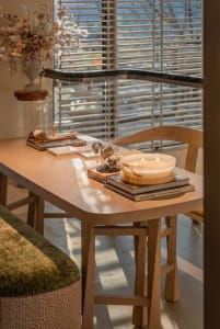 Dining room with a wooden table and chairs, a cozy atmosphere, and natural light from the windows