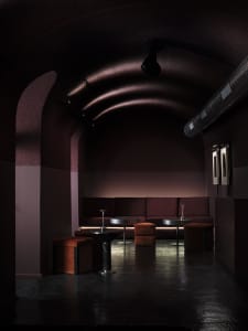 Cozy dining room with a purple wall, red ceiling, wooden walls, and a dining table, bar counter, and couches
