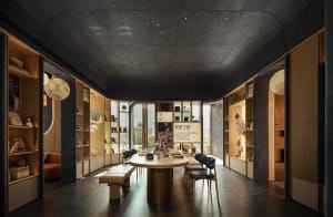 Cozy dining space with a round table, blue walls, and comfortable chairs, surrounded by books and additional seating
