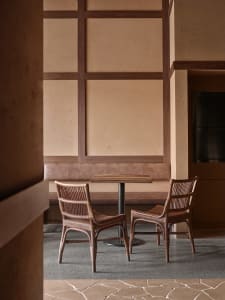 A warm and inviting dining area with a table surrounded by chairs and a bench, well-lit by natural light through the windows