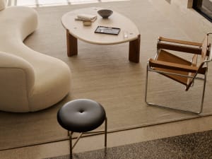 Cozy modern living space with a black table, rug, couch, chair, and well-lit atmosphere