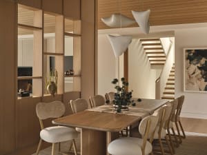 Dining room with a wooden table and chairs, a potted plant, and warm lighting
