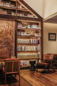 Cozy room with a wooden bookshelf filled with books, a leather chair, and a warm atmosphere
