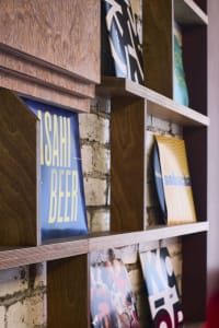 A wooden bookshelf filled with various books of different sizes, arranged in a cozy and organized space, likely a home library or bookstore