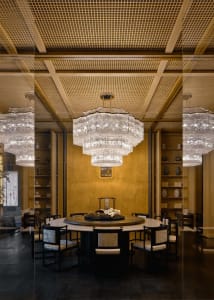Formal dining room with a gold and white color scheme, a large dining table, and elegant vases