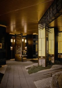 A rendered hallway with a black and gold color scheme, decorated with a vase and potted plants, featuring soft and warm lighting