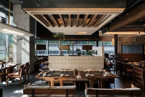 Cozy restaurant with a wooden floor, brick wall, and tables set for dining