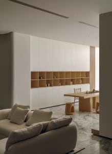 Cozy living room with a couch, chair, and dining table, surrounded by white walls and wooden floors, with soft and warm lighting