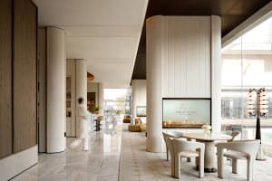 Well-lit lobby with a large TV, comfortable seating, decorative elements, and a sophisticated atmosphere