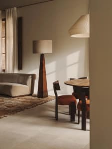 Comfortable living space with a couch, chair, dining table, and various decorative items, lit by natural light and warm ambiance