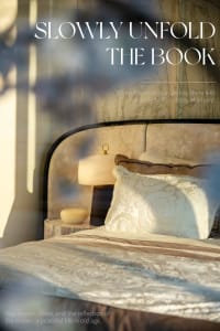 Cozy bedroom with a bed, nightstand, and lamp, featuring a wooden headboard and natural light from a window