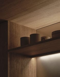 A well-lit kitchen with wooden cabinets and shelves, creating a warm and inviting atmosphere