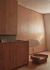 Well-lit kitchen with wooden cabinets, a sink, and a bowl on the countertop, creating a warm and cozy atmosphere