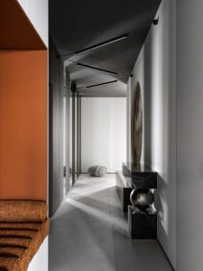 A bright and welcoming hallway with a white wall, brown floor, a bench, a table, and a few balls, in a modern style with clean lines and minimalistic design elements