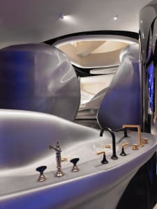 A modern bathroom with a sink, bathtub, and toilet, featuring ceramic or porcelain fixtures in a well-lit and clean space