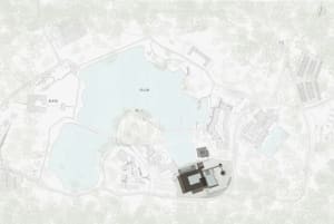 A simple white drawing of a building with a lake in the foreground, featuring a large building and a smaller building nearby