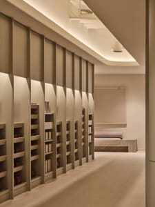 A study area with a large wooden bookshelf filled with books, creating a cozy and intellectual atmosphere