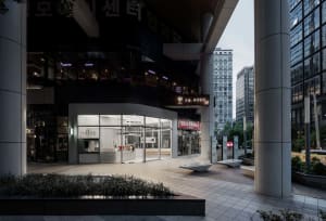 A modern coffee shop with a large window and a bench outside, providing a welcoming atmosphere for customers