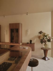 A dimly lit kitchen with a wooden countertop, a wooden cabinet, and a vase, creating a warm and inviting atmosphere