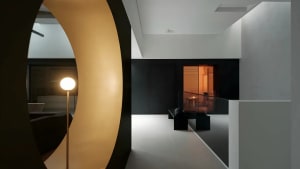 Black and white dining room with a glass door, a table, and a chair, featuring a modern style with clean lines and minimal decoration