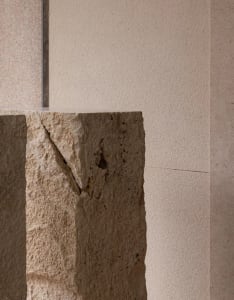 A stone wall with a large rock in the foreground, taken from a low angle to emphasize depth and perspective