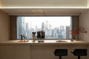 Modern kitchen and dining space with a large window offering a city view, marble countertops and flooring, and a glass window, featuring a chair, potted plant, and dining table