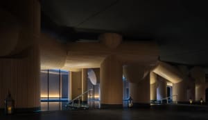 A dimly lit lobby with a large wooden dome and spiral staircase, creating a cozy and inviting atmosphere
