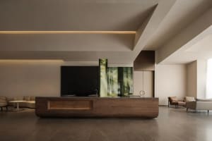 Modern kitchen with a wooden countertop, a black TV, and a dining table, featuring dim lighting
