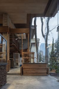 A commercial building with a glass facade and a large wooden structure, featuring a large window and natural light