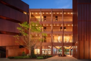 A modern lobby and dining area with a red brick exterior, concrete floors, and natural light from the atrium