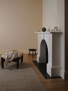 Comfortable living space with a white fireplace, a chair, a couch, and a bowl on a surface, well-lit and inviting