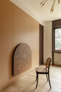 Cozy living space with a chair and couch, wooden floor, and natural light from a window