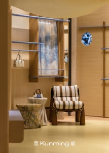 a modern retail space with a wooden floor and a chair, featuring a display of handbags and a clock on the wall