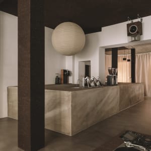 A modern kitchen with a marble counter, metallic sink, and dim lighting, creating a cozy atmosphere