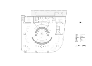 A 2D floor plan of a modern building with a large open space featuring a circular center, surrounded by other rooms, with clean lines and minimal decoration