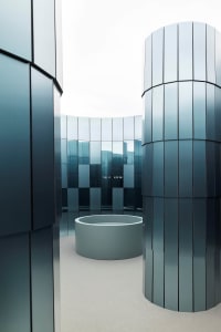 A modern building with a large, open space featuring a circular pool and large windows allowing natural light to fill the space